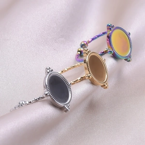Adjustable oval stainless steel rings in silver gold and rainbow colors on pink silk