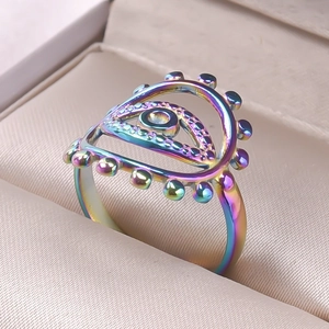 Detailed macro view of an iridescent rainbow evil eye stainless steel open ring in a box