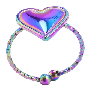 Macro shot of rainbow-colored heart ring with textured band and polished metal finish