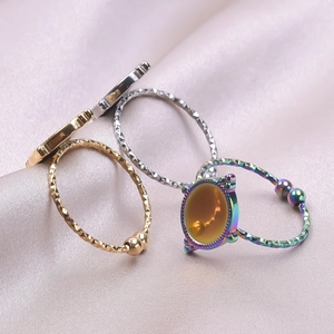 Detail of bohemian rainbow coated ring with orange oval stone on purple silk fabric