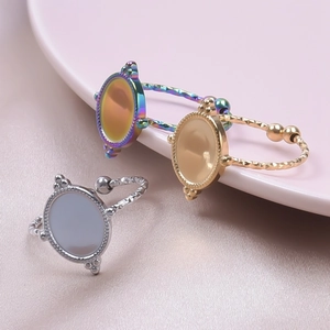 Detailed set of three stainless steel rings with beaded oval faces on a pink silk background