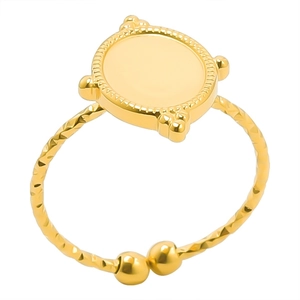 Detailed shot of golden ring with flat disc top and adjustable twisted metal band texture