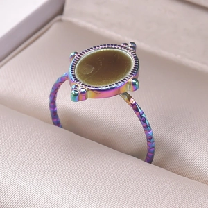 Macro detail of iridescent stainless steel adjustable ring with geometric texture and brown inlay