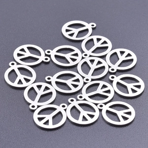 Macro shot of silver stainless steel peace sign charms with small jump rings for DIY jewelry