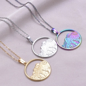 Colliers avec pendentif montagne en trois couleurs sur un tissu en soie violette