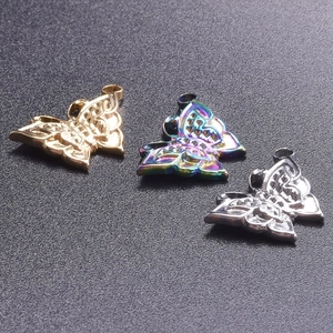 Détail macro de pendentifs papillon ajourés en finitions or, argent et irisées