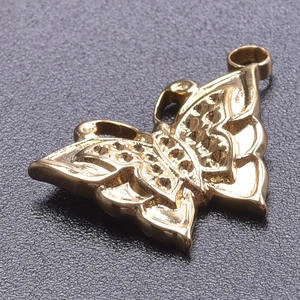Vue macro d'un pendentif papillon doré avec détails de gravure évidés précis