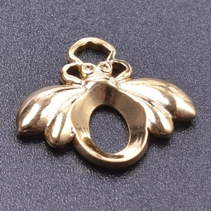Vue macro d'un charme abeille plaqué or 18k avec polissage miroir et fente sertie