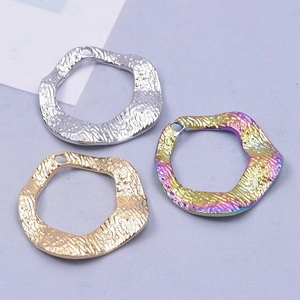 Detailed view of irregular hammered metal pendants in gold, silver, and rainbow colors