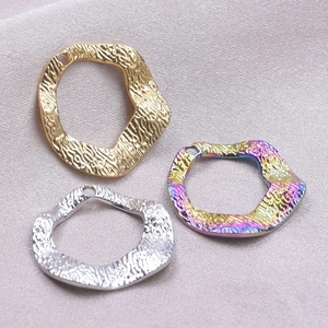 Detailed view of irregular wavy hammered metal pendants in gold silver and rainbow colors