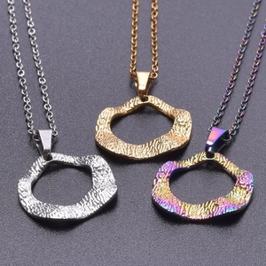 Macro detail of irregular geometric pendant necklaces with textured hammered finish in gold and silver