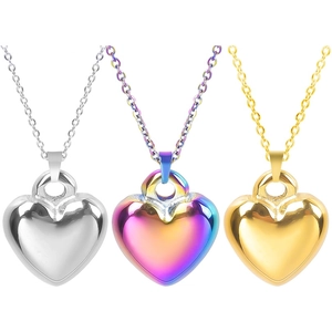 Detailed view of heart-shaped pendants in gold, silver, and rainbow stainless steel