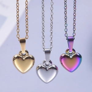 Three minimalist stainless steel heart necklaces in gold, silver, and iridescent finishes