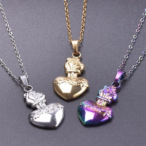 Vue détaillée des pendentifs Sacred Heart en argent, or et irisé sur un fond en pierre sombre