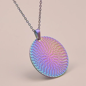Macro detail of iridescent round pendant with spiral mesh texture on O-link chain