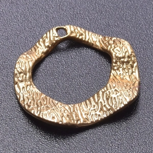 Macro shot of 18k gold plated stainless steel irregular pendant with hammered lava texture