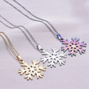 Polished snowflake pendant necklaces in gold, silver and rainbow on purple silk fabric