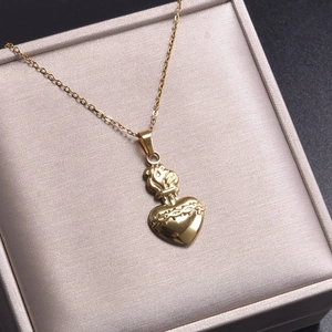 Vue détaillée du pendentif Cœur Sacré en acier inoxydable plaqué or 18 carats avec flamme
