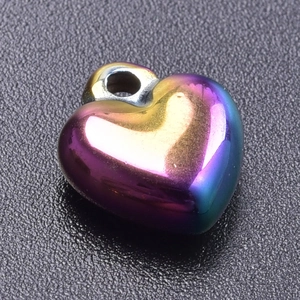 Macro detail of rainbow iridescent heart pendant in polished 18k plated stainless steel