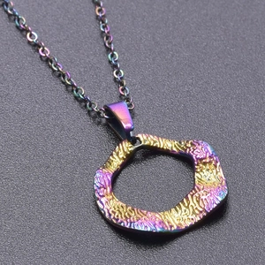 Macro detail of irregular round pendant with rainbow metallic finish and hammered texture