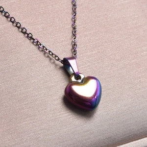 Macro shot of an iridescent heart pendant necklace on premium silk background
