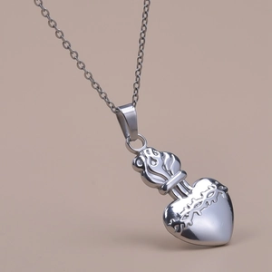 Gros plan détaillé d'un collier pendentif cœur argenté à texture d'épines style punk
