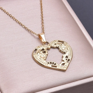 Makroaufnahme des 18k Gold Herzanhängers mit Zahnrädern auf rosa Schmuckschatulle