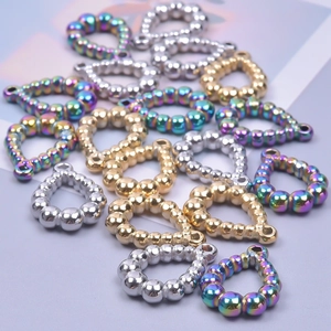 Macro detail of textured teardrop metal charms in gold silver and rainbow finishes