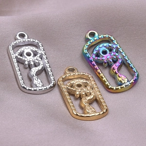 Macro shot of evil eye and snake pendants in gold, silver, and rainbow finishes