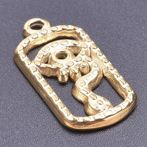 Close-up of a vintage gold snake pendant with detailed scales and engraved rectangular frame