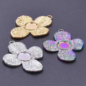 Detailed macro view of four-petal flower charms with leaf vein textures in gold and silver