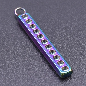 Macro shot of a rainbow-plated rectangular stainless steel pendant with textured grooves