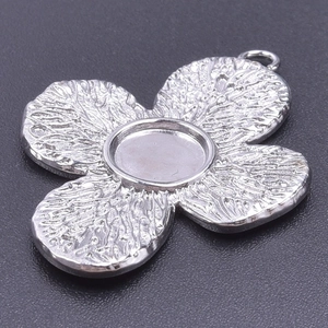 Macro view of silver flower-shaped pendant base for DIY stainless steel jewelry making