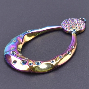 Macro detail of teardrop pendant with iridescent plating and inlaid crystals