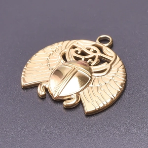 Macro detail of a 18k gold-plated stainless steel scarab beetle pendant with hollow wings