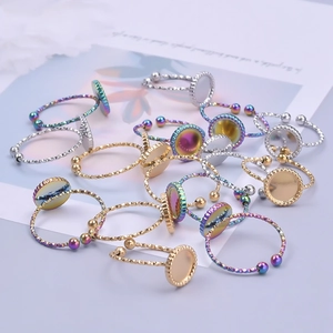 Detalle de bases de anillos DIY con bandejas redondas en acabados oro, plata e irisado
