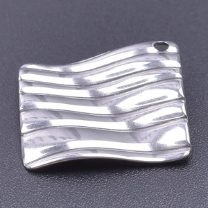 Vue macro d'un pendentif rectangulaire argenté à texture ondulée avec trou pour DIY