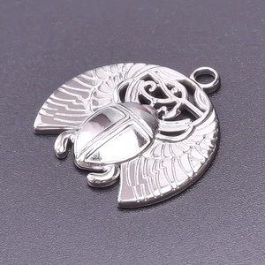 Macro detail of a silver scarab beetle pendant with intricate wing texture and engraving