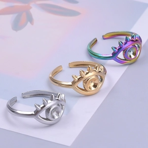 Dettaglio di tre anelli regolabili malocchio con finiture in argento, oro e arcobaleno