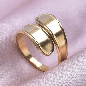 Macro shot of minimalist gold adjustable geometric ring on pink silk fabric background