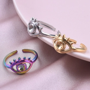 Anelli regolabili malocchio in argento, oro e arcobaleno su un tessuto di raso rosa