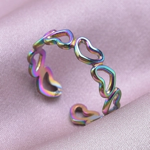 Macro-opname van de regenboog hartvormige open ring op zachte roze zijden stof