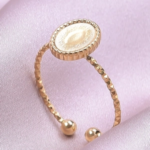Vista macro de anillo ajustable dorado de acero con superficie ovalada y pequeñas bolas