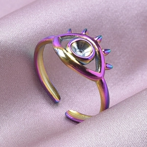 Macro dell'anello Evil Eye iridescente su seta viola con dettagli a punta