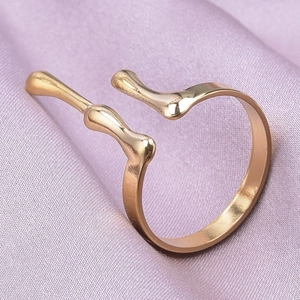 Macro shot of gold stainless steel geometric lava ring on soft purple silk fabric