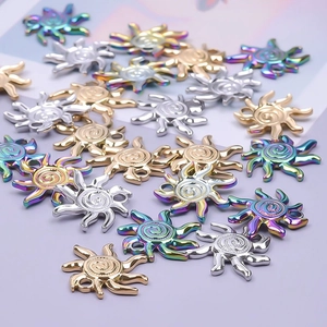 Detailed macro of sun-shaped stainless steel charms in gold, silver, and rainbow finishes