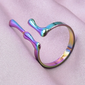 Macro view of rainbow iridescent liquid lava ring on soft pink silk background