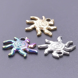Macro detail of sun-shaped stainless steel pendants in gold, silver, and rainbow finishes