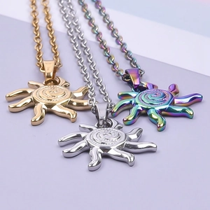 Detailed view of sun-shaped pendants in gold, silver, and rainbow plating on a soft purple background