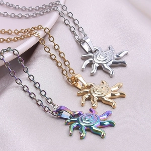 Detailed macro view of sun totem necklaces in gold, silver and rainbow finishes